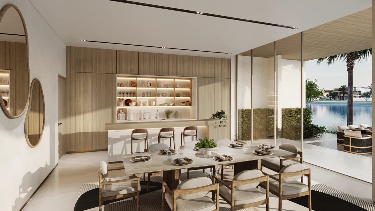 Dining table and kitchen island in pale oak, opening onto the sea-facing terrace.