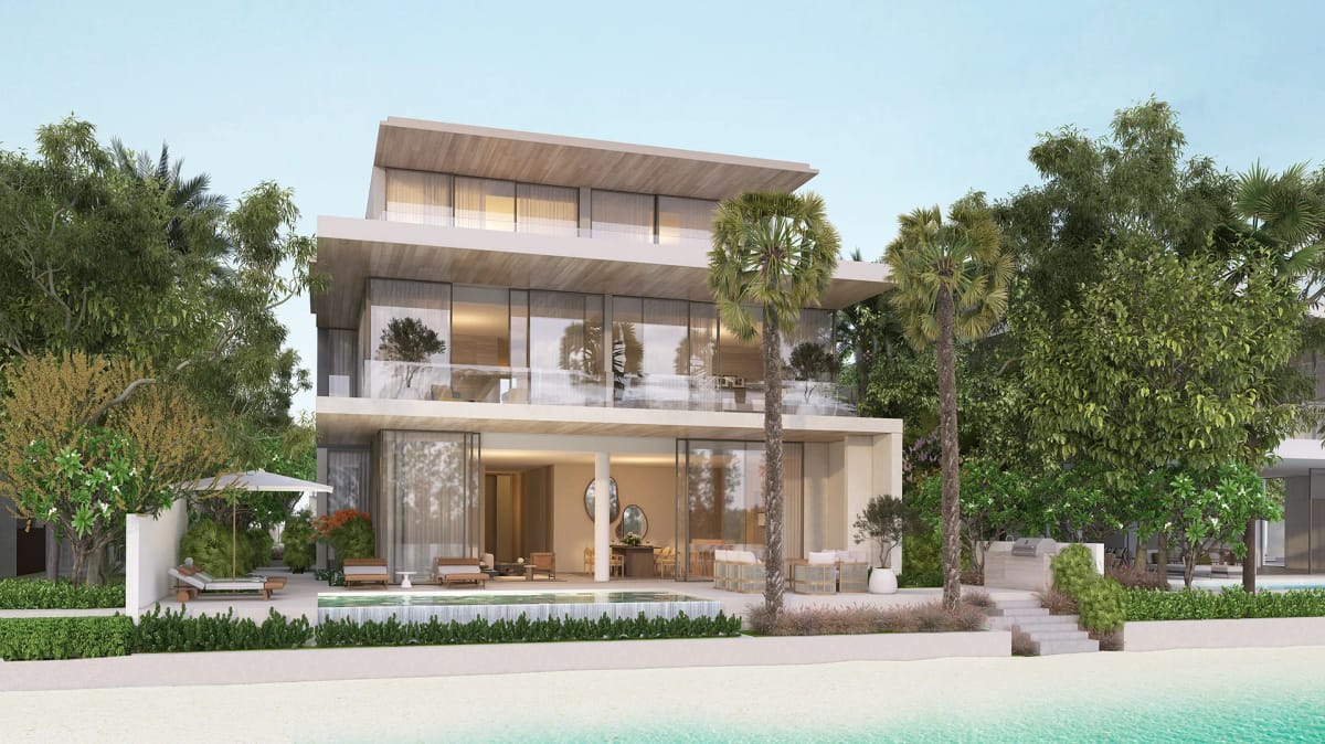 Wave Crest villa seen from the beach, with the pool terrace, palm-shaded garden and the Arabian Gulf in the foreground.